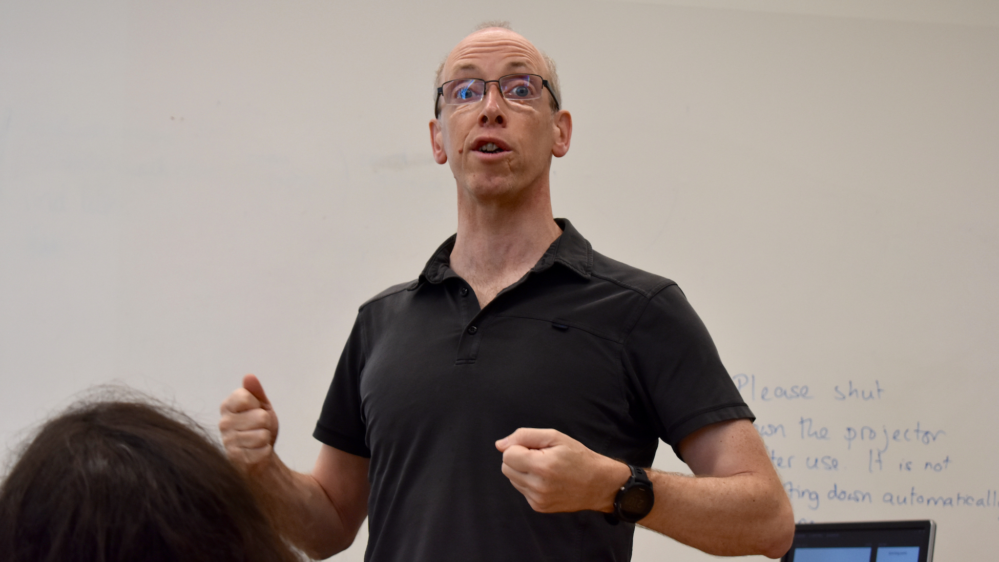 Professor Colin Phillips, in a black short-sleeved collared athletic shirt, making an introduction