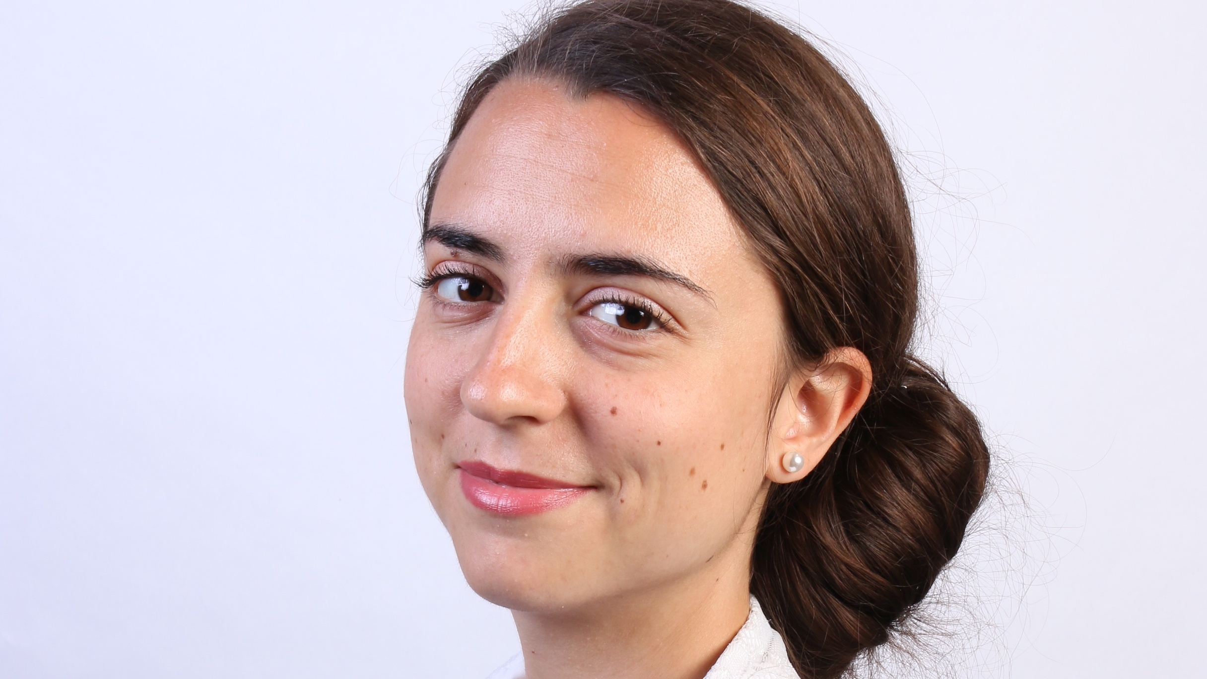 A portrait of Luisa Seguin, PhD student in Linguistics, turned toward the camera in three-quarter profile 