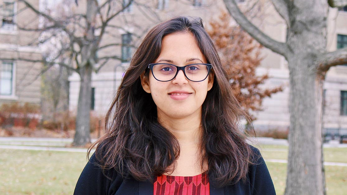 A portrait of postdoctoral fellow Shohini Bhattasali, outside and smiling at the camera