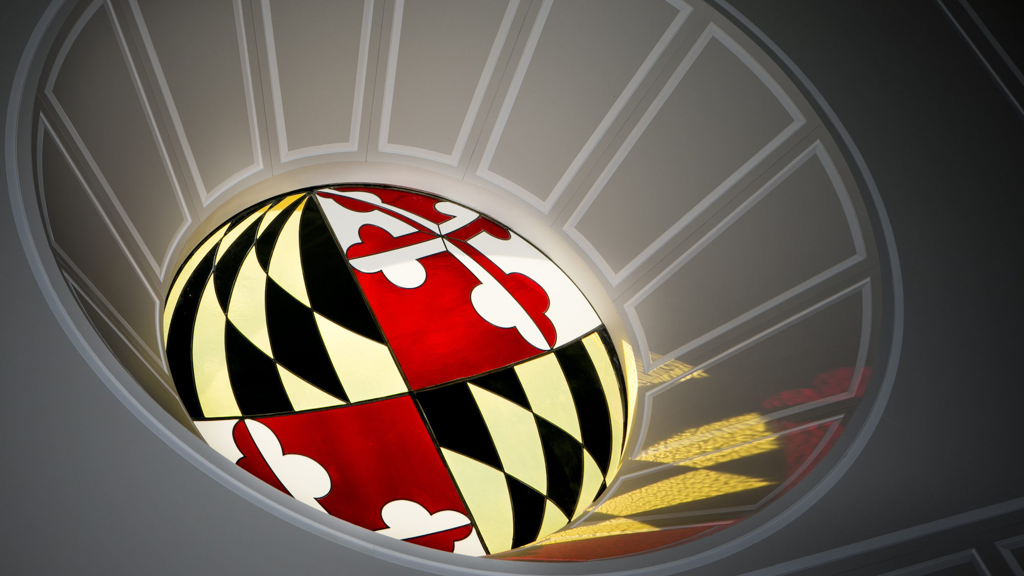 A circular stained glass window of the Maryland state flag