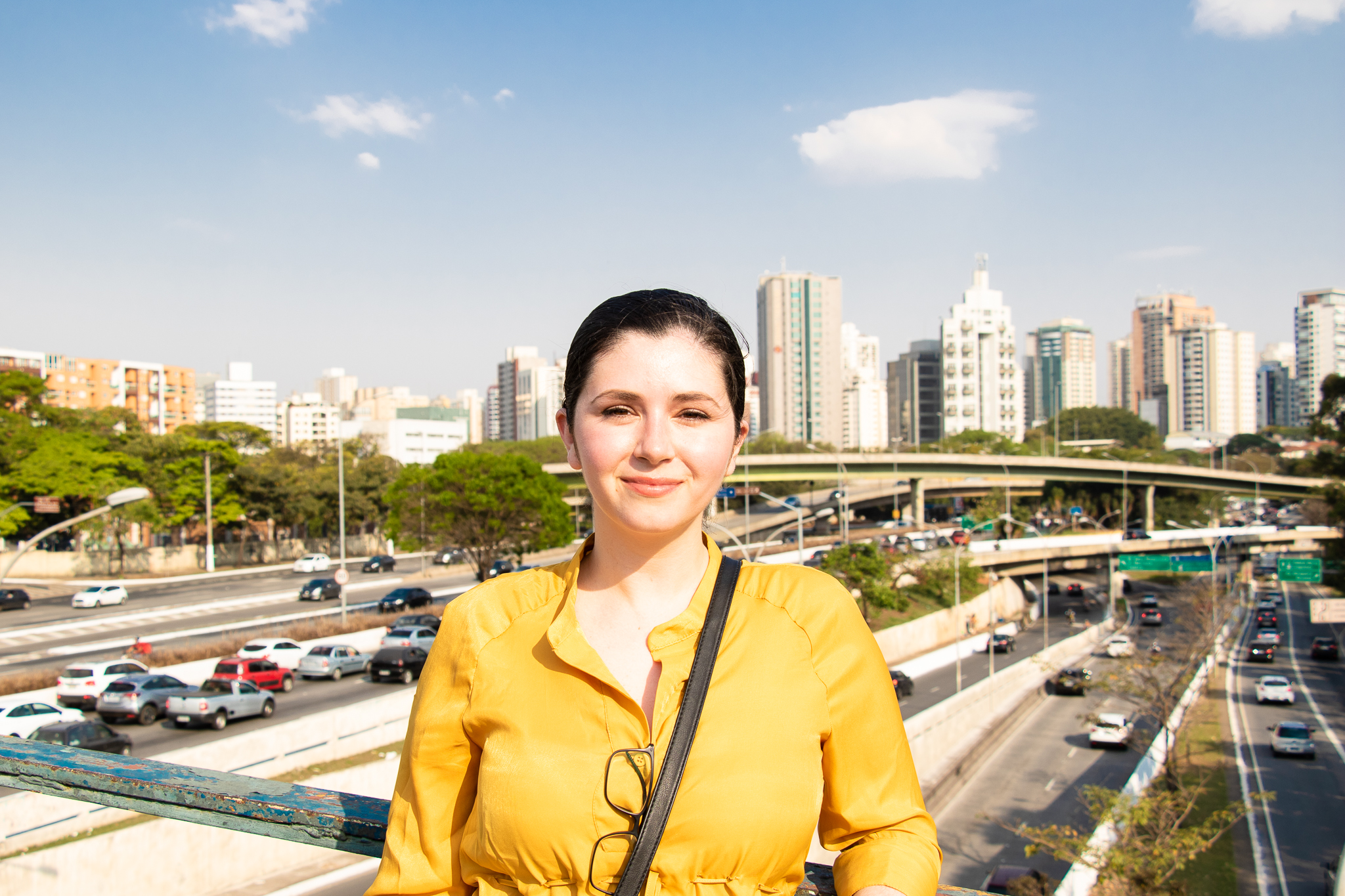PhD student Jessica Mendes, standing on a bridge over a busy highway in Brazil