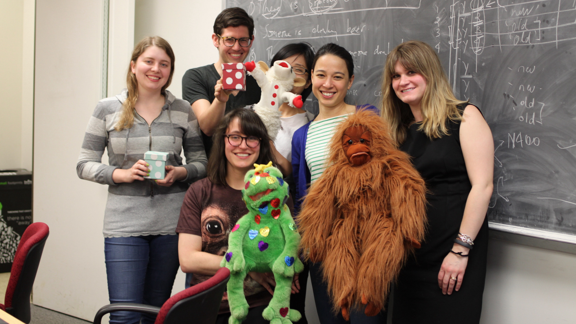A group of students surrounding Linguistics professor Valentine Hacquard, who is holding a large orangutan stuffie.