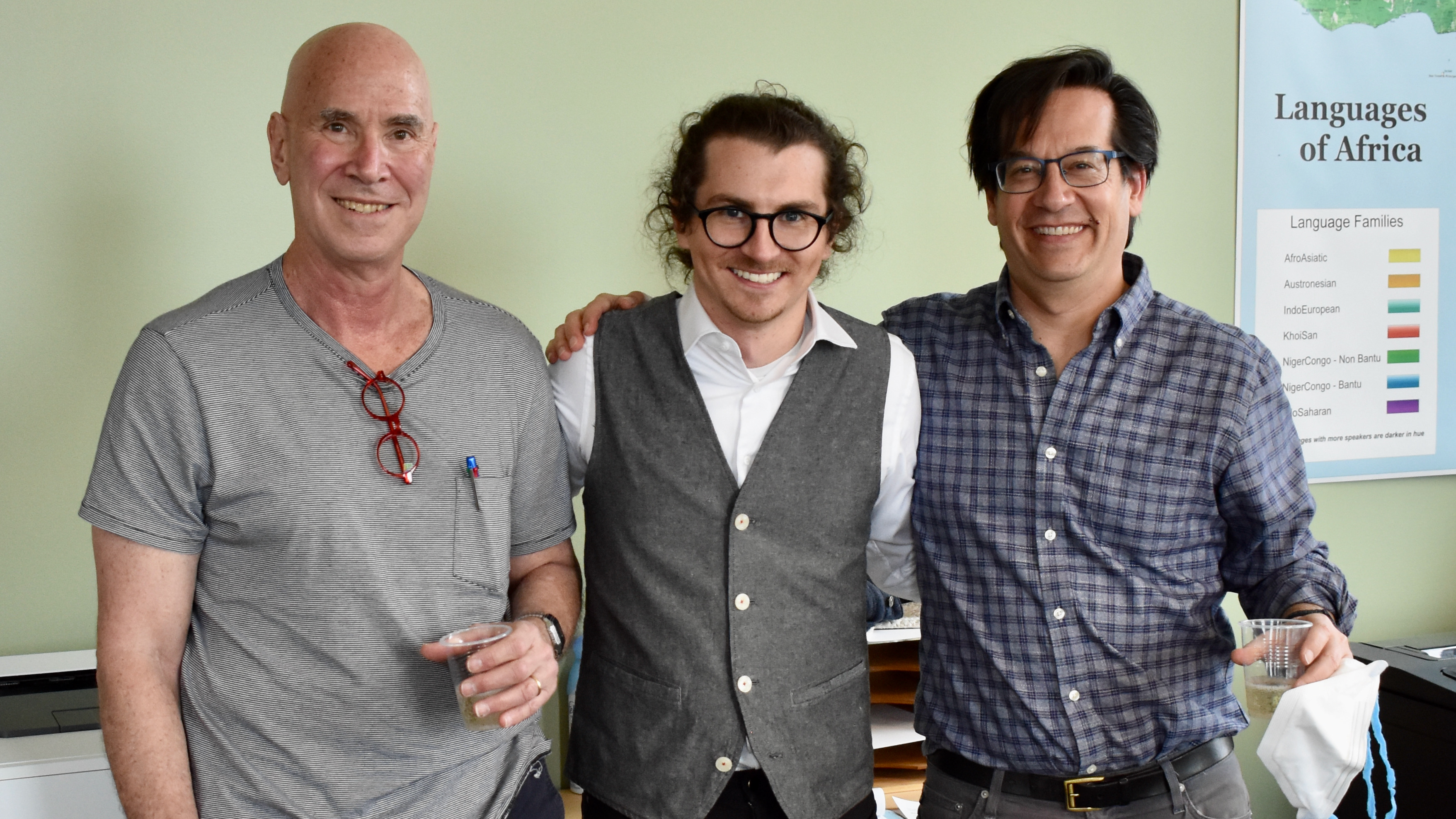 Adam Liter, a PhD student in linguistics, standing happily between his two dissertation chairs, Norbert Hornstein and Jeff Lidz, with his arms around them.