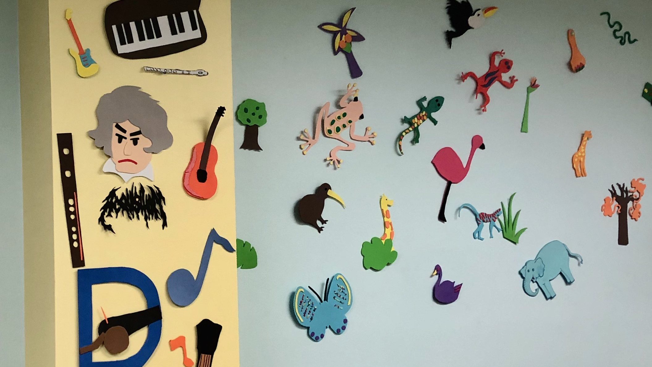 Cut-out art for children, depicting animals and musical instruments, on the walls of an infant-research lab.