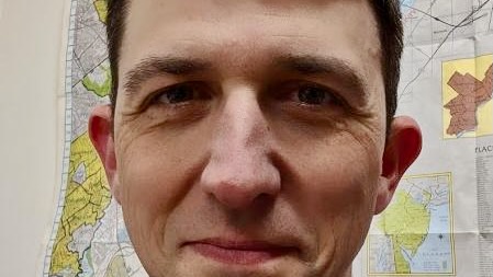 Close portrait of the face of a young man smiling.