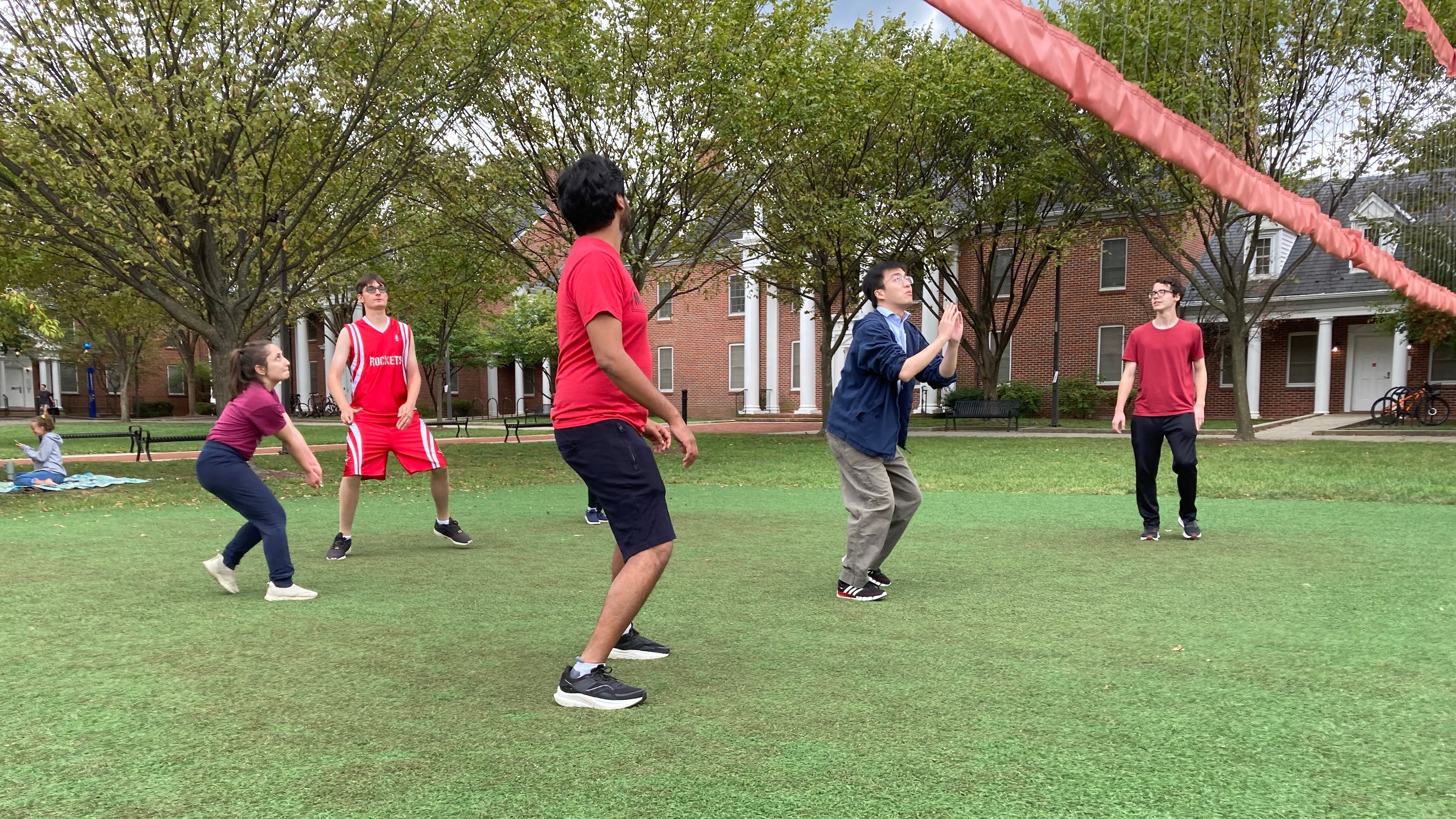 A group of graduate students playing volleyball.