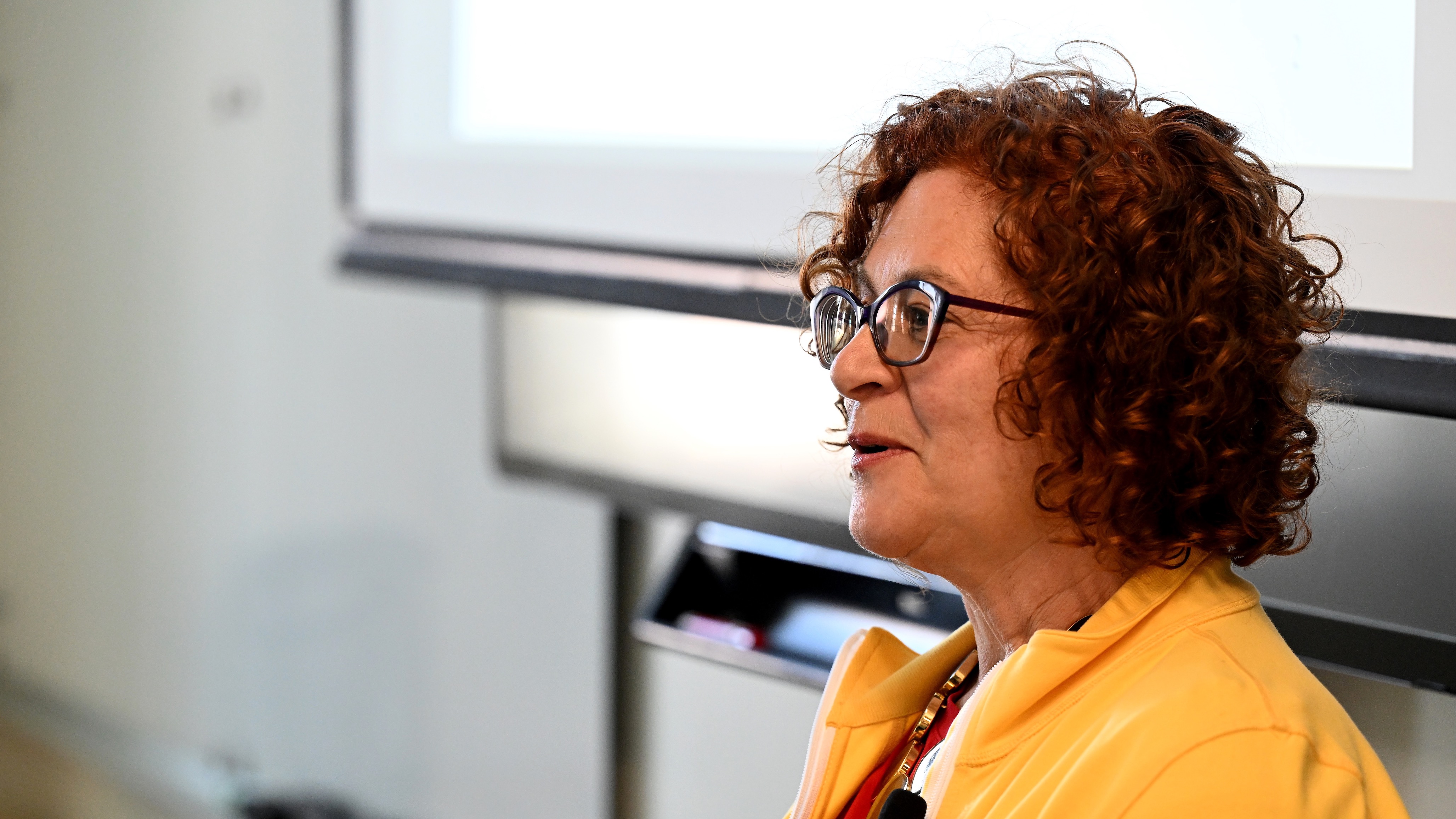 Profile photo of a woman in a bright yellow jacket.