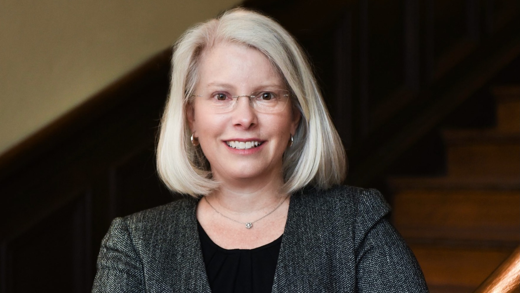 Professional photo of a woman in a grey suit.