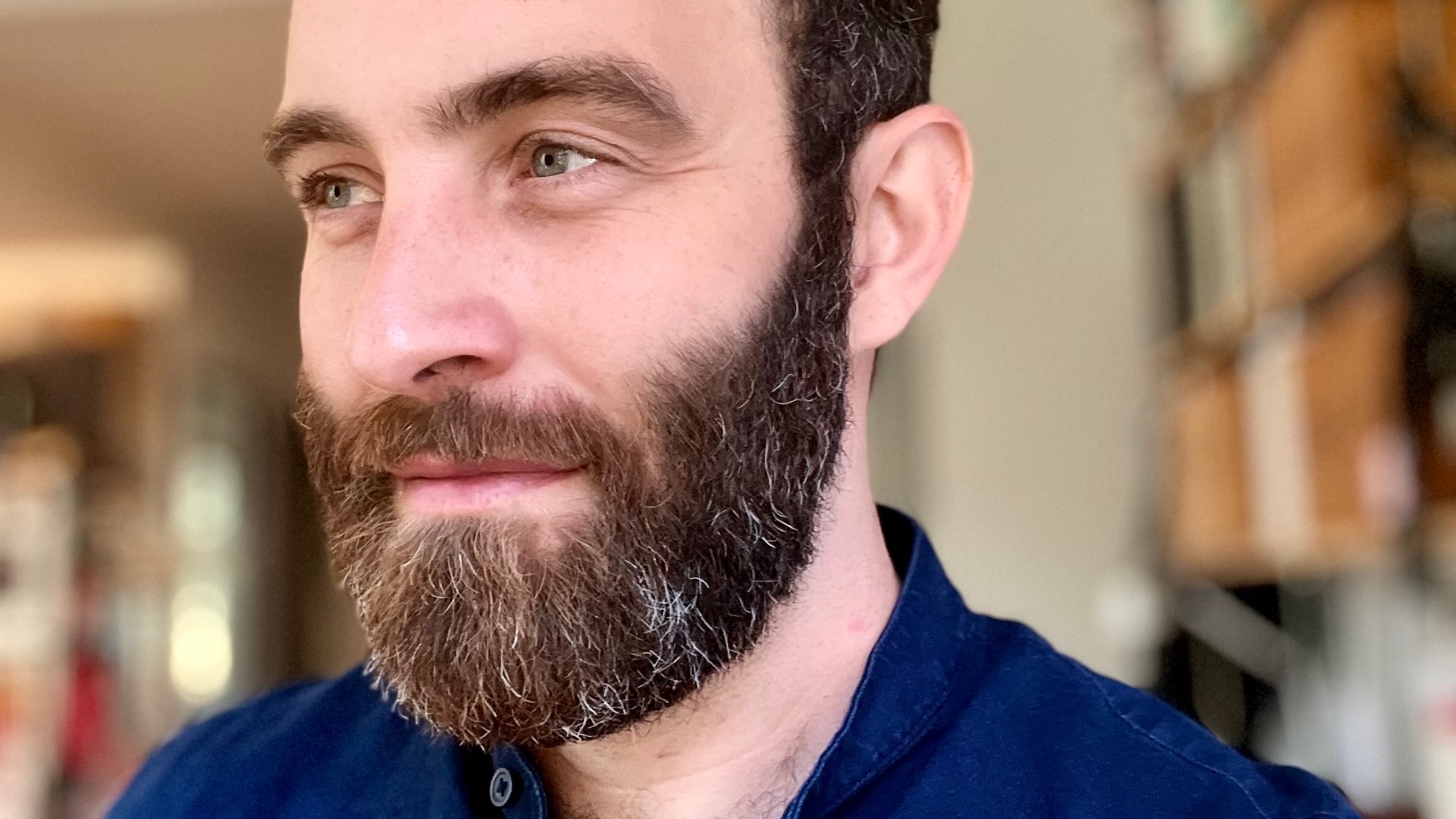 Close portrait of a brown-haired man with a beard.