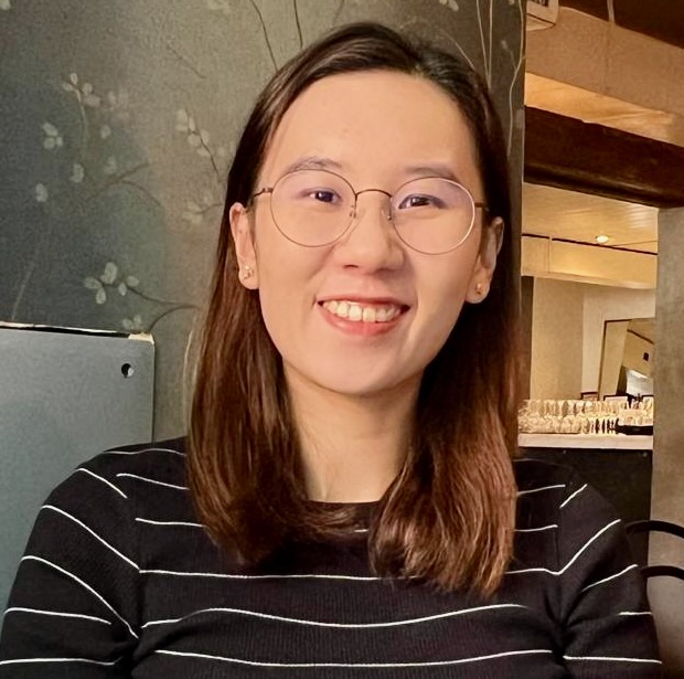 Portrait of a young woman, sitting in a cafe, smiling straight at the camera.