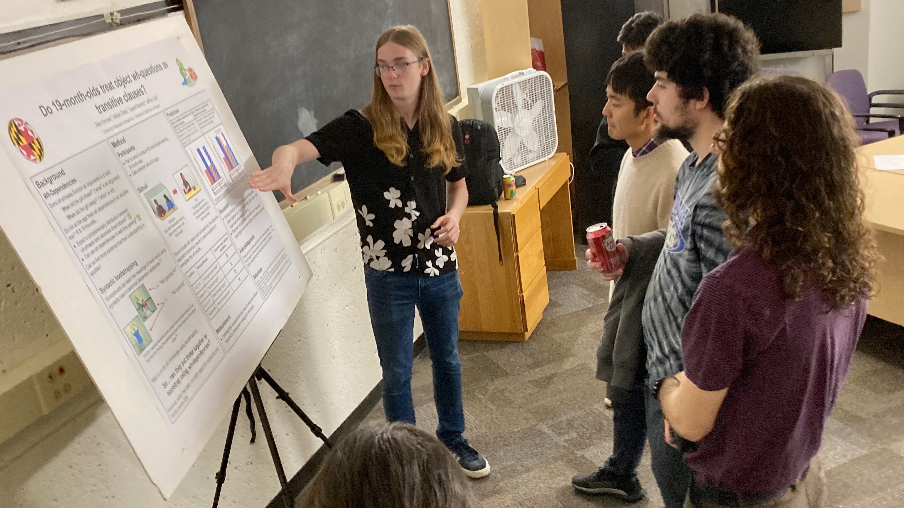 A student presenting a poster describing their research.