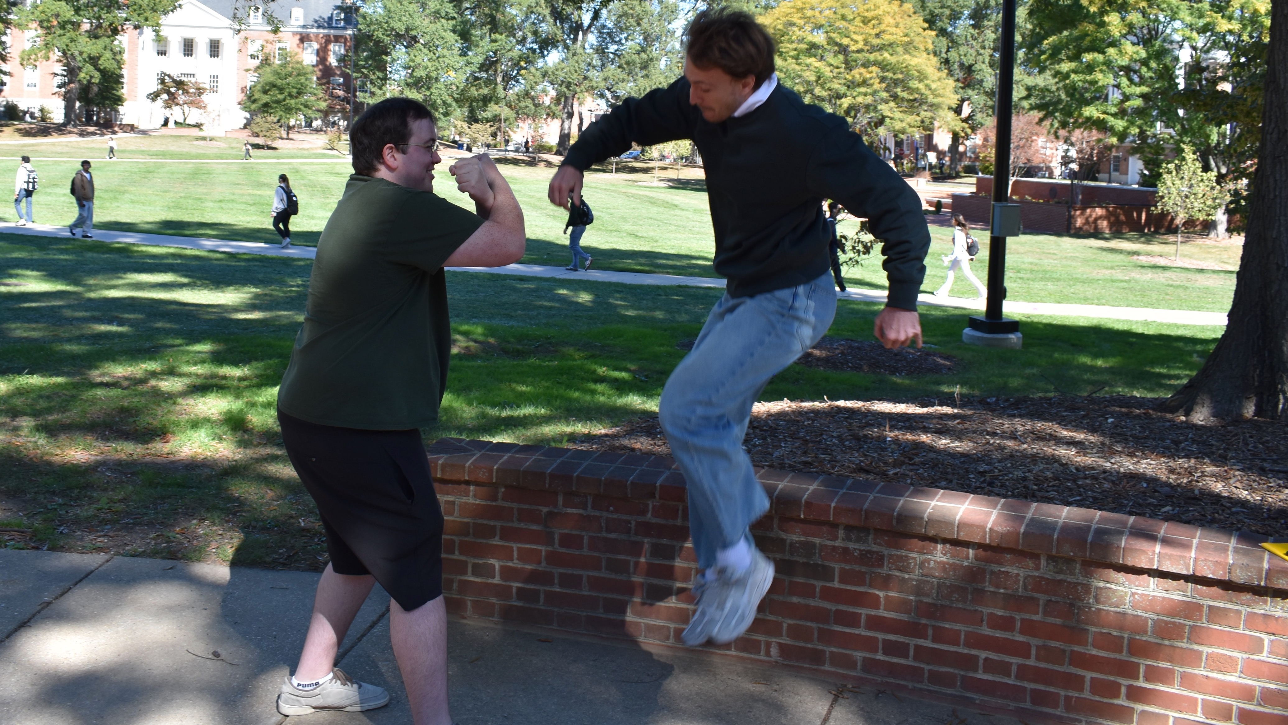 One young man jumping towards another with his fists ready to punch.