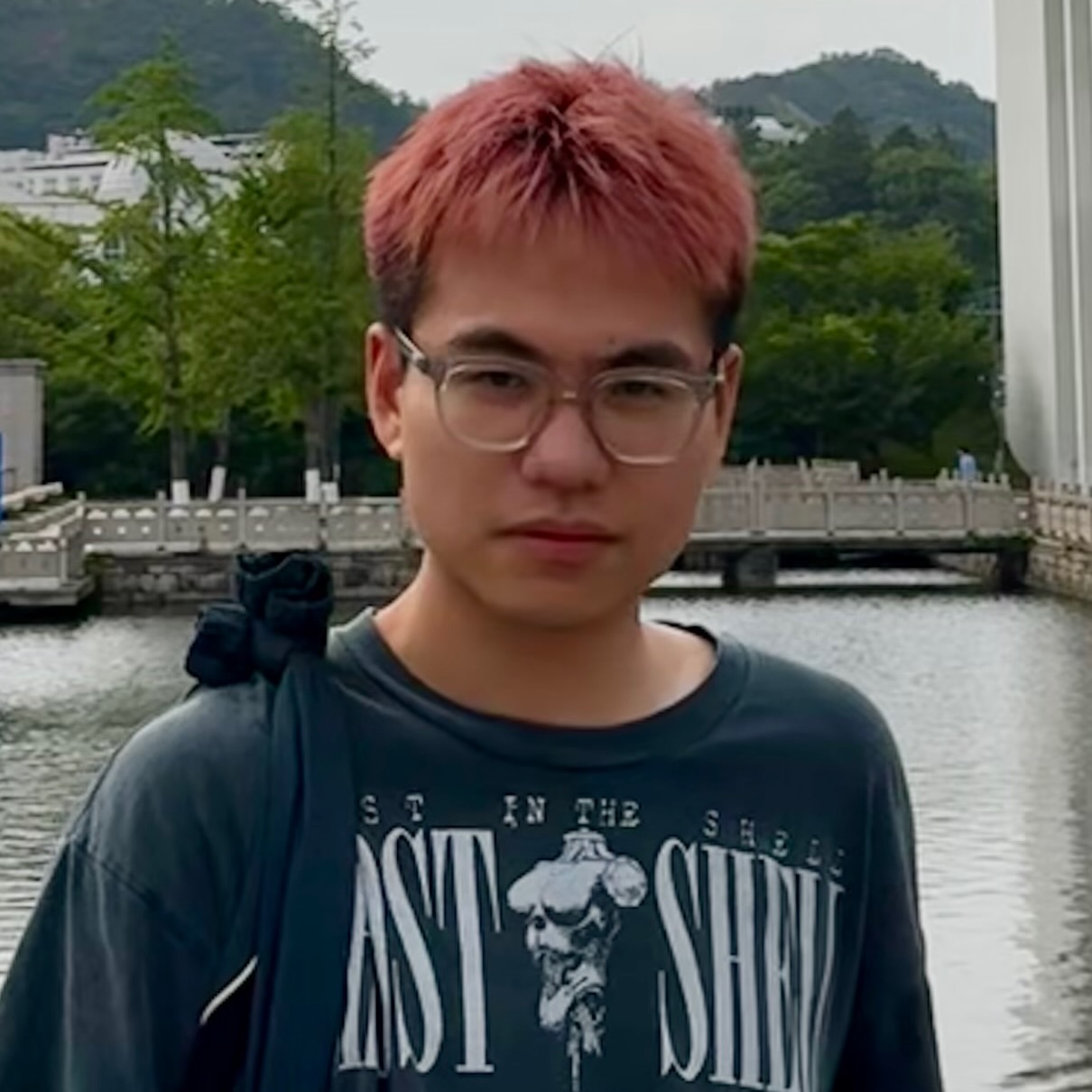 A young man standing outside.